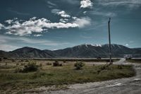 Parkplatz inmitten der Berge, blauer Himmel, leicht bew&ouml;lkt, Strommast, Roadtrip-Stimmung, Reisen, - by Erik Chemnitz