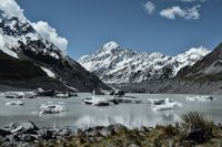 Glacier Lake with Aoraki/Mount Cook, New Zealand, West Coast, Mackenzie District region of Canterbury. Blue sky, partly cloudy, sunshine. Travel the world on a road trip.